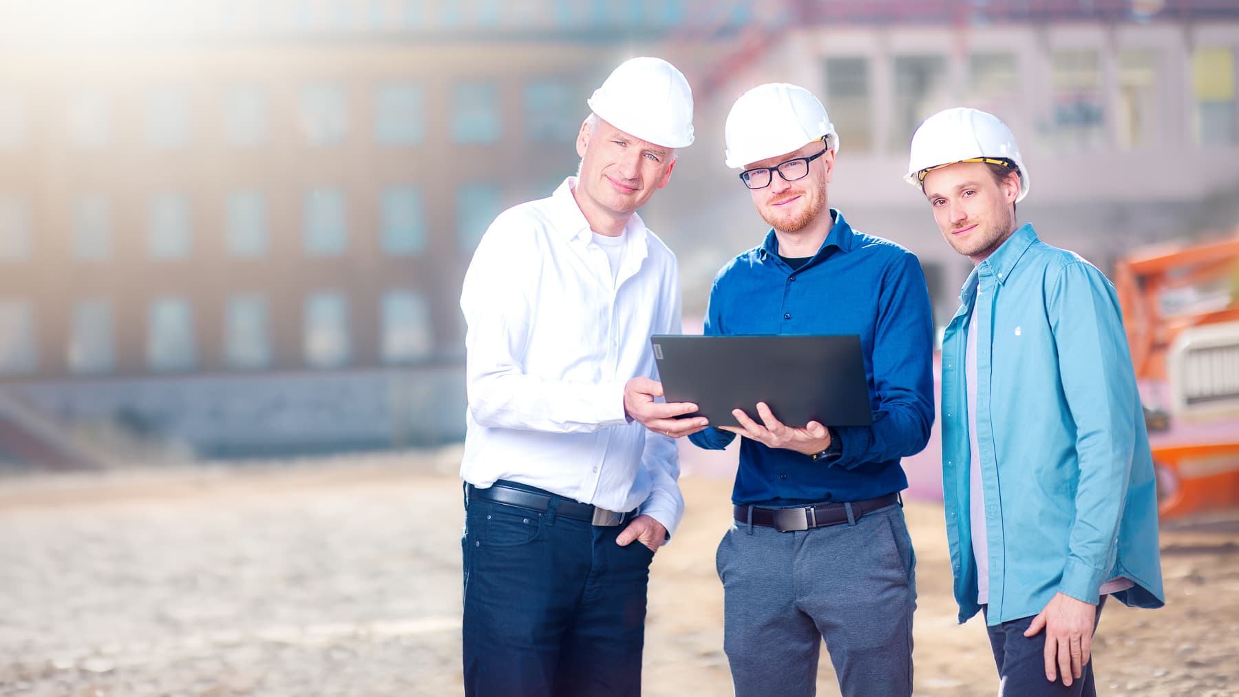 Bauleitung des ik Ingenieurbüro Knoblich auf der Baustelle mit Laptop und Bauplan